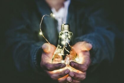 man holding incandescent bulb